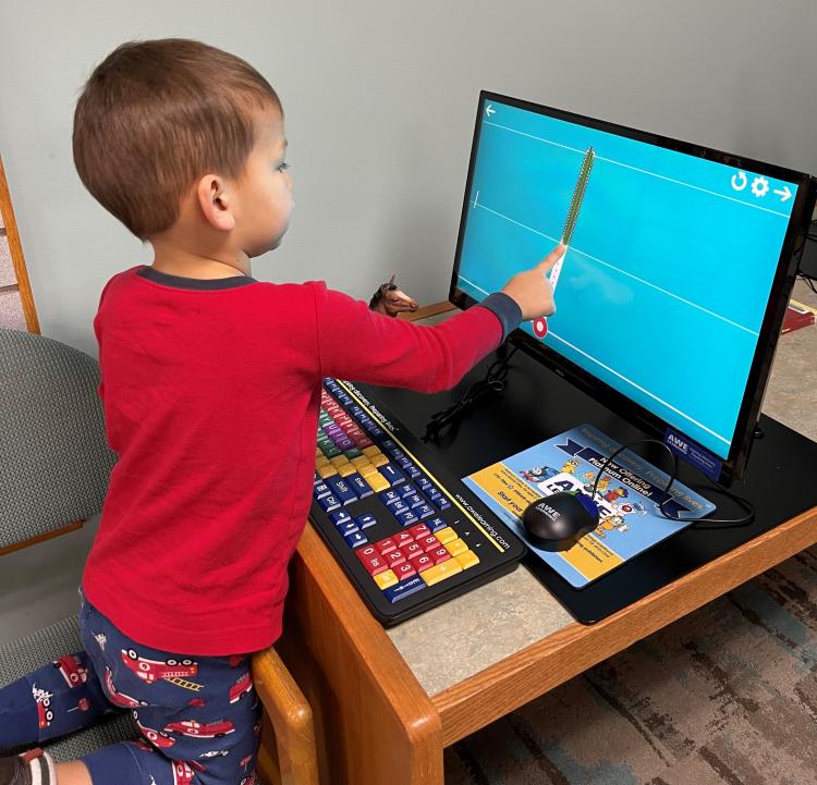 preschooler using the touchscreen of an educational computer